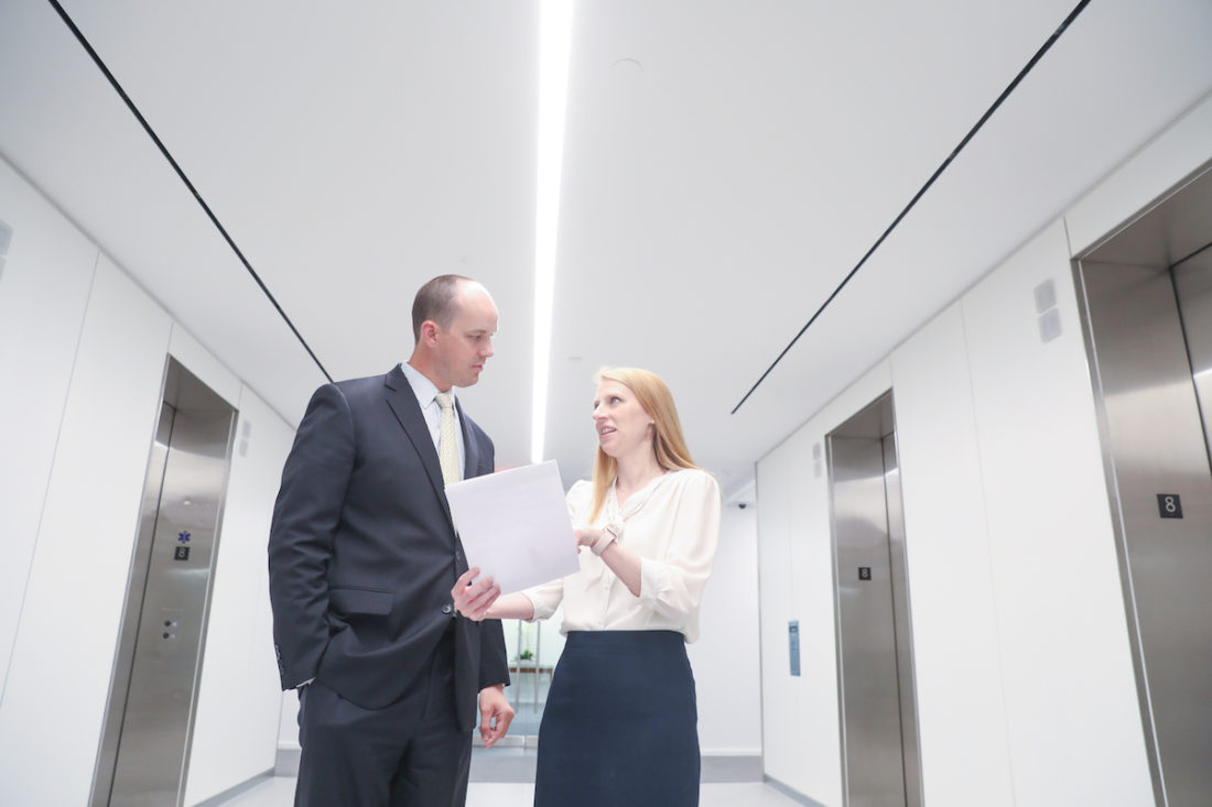 Attorneys Glaws and Conkright discussing a document in the hallway.