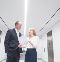 Attorneys Glaws and Conkright discussing a document in the hallway.