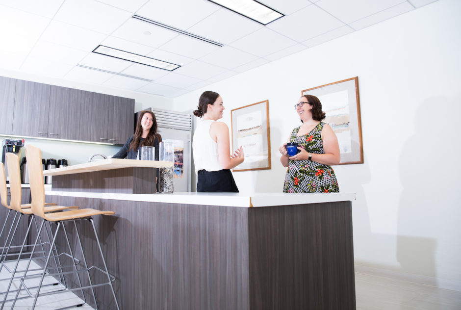 Staff members having a lively conversation in the break room.